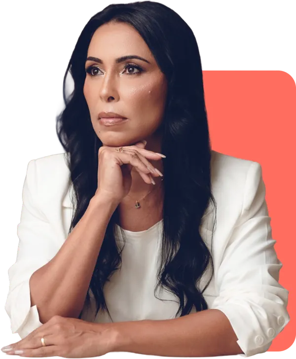Retrato de Geórgia Durães, de blazer branco, com a mão no queixo, sobre um bloco coral